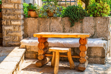 Outdoor living area with wooden table and a bench in a garden