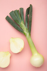 Green onion on pink background. Vertical photo