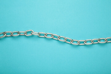 Iron chain of light metal on blue background.