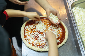 Children participate in a pizza-making master class. 