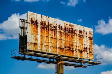 Rusty billboard against blue sky advertising space outdoor signage weathered structure metal decay urban blight