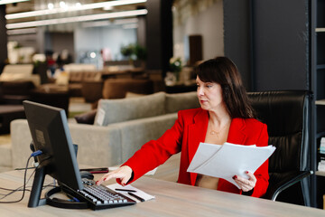 Businesswoman working with computer and documents in modern office