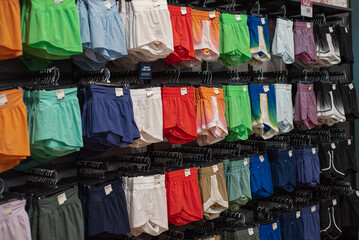 Vibrant array of female athletic, stride high-rise shorts displayed in sporty retail setting,...