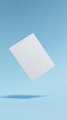 An isolated white rectangular piece of paper gracefully floats against a clean light blue backdrop