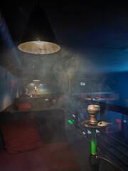 Atmospheric hookah lounge interior with thick smoke and modern lighting for relaxation and social...