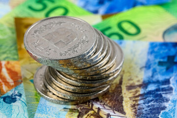 A pile of coins arranged on top of banknotes, CHF currency