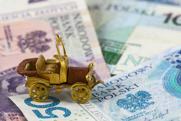 A small retro car model and Polish zloty banknotes