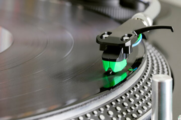 Cartridge mounted in headshell at the end of the tonearm reads music from a vinyl record