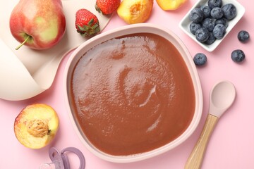 Baby food. Tasty puree in bowl, spoon and ingredients on pink table, flat lay