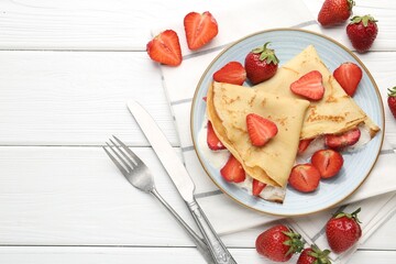 Delicious crepes with strawberries and cream on white wooden table, flat lay