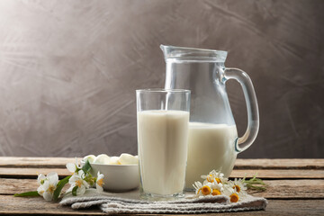 Fresh milk, mozzarella balls and flowers on wooden table. Dairy products