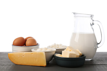 Different dairy products and eggs on grey wooden table against white background