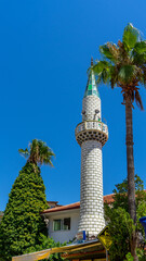 Minaret of mosque in town or village Turunc, Turkey. Muslim religious institutions in Turkiye. Vertical image
