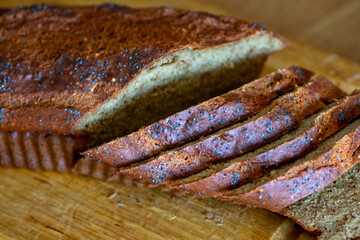Homemade loaf of poppy seed bread on wooden cutting board
