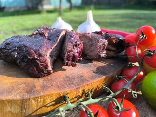 juicy steak on a chopping board surrounded by vegetables and fruits. High quality photo