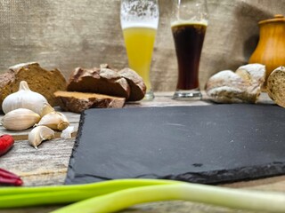 slices of bread and glasses of beer are located near the sliced granite board