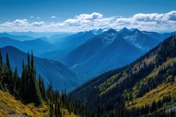 Obraz premium Panoramic view of blue mountain ranges with lush greenery and distant peaks under a clear sky