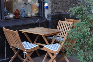 Outdoor cafe seating arrangement with wooden furniture