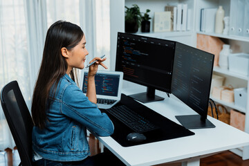 Young Asian IT developer looking online information on pc for beautiful pose with coding program...