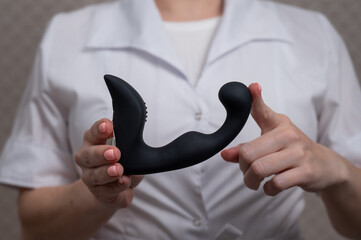 Female doctor holding prostate stimulator. 
