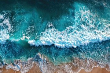 Seething ocean waves with foam cresting above sandy beach captured from an aerial perspective in bright daylight