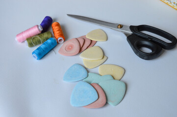 colorful sewing supplies including spools of thread tailor’s chalk scissors arranged on a white surface tailoring handmade fashion, sewing tools, dressmaking creative hobbies