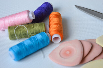 colorful sewing supplies including spools of thread tailor’s chalk scissors arranged on a white surface tailoring handmade fashion, sewing tools, dressmaking creative hobbies