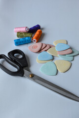 colorful sewing supplies including spools of thread tailor’s chalk scissors arranged on a white surface tailoring handmade fashion, sewing tools, dressmaking creative hobbies
