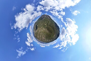 Asarlik Hills Natural Monument Miniature landscape panorama of a lush green island under a vibrant blue sky.A captivating miniature-world-style image showcasing a small, verdant island with a mix of 
