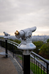 Coin-operated binocular overlooking scenic viewpoint under cloudy sky