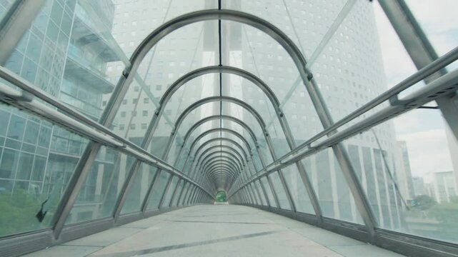 Walking through modern glass skybridge in business district