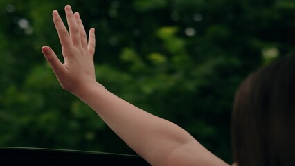 Little girl waving from car window. Child passenger enjoying ride. Child riding with family in car enjoying ride. Happy kids vacation. Car driving on road, family trip. People traveling