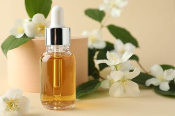 Cosmetic product and jasmine flowers on beige background, closeup