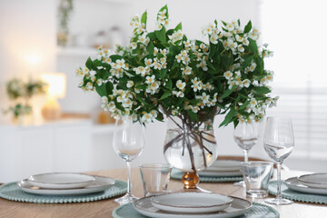 Bouquet of beautiful jasmine flowers on dining table indoors