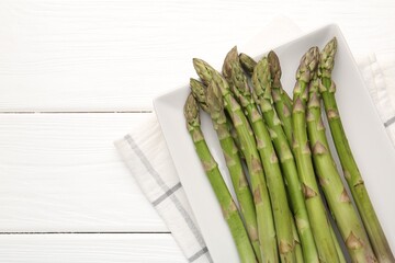 Fresh raw asparagus spears on white wooden table, top view. Space for text