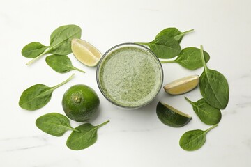 Tasty spinach smoothie and ingredients on white table, flat lay