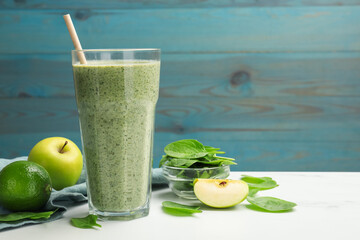 Tasty spinach smoothie and ingredients on white marble table, closeup. Space for text