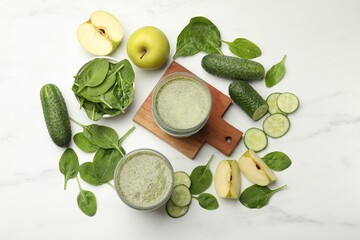 Tasty smoothie and spinach leaves on white marble table, flat lay