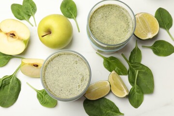 Tasty smoothie and spinach leaves on white marble table, flat lay