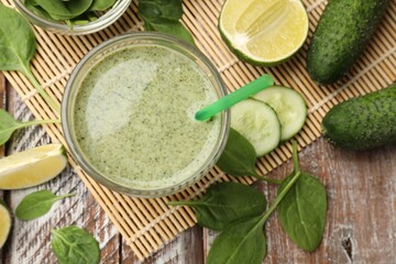 Tasty spinach smoothie and ingredients on wooden table, flat lay