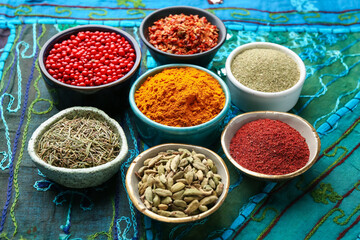 Different aromatic spices on blue tablecloth, closeup