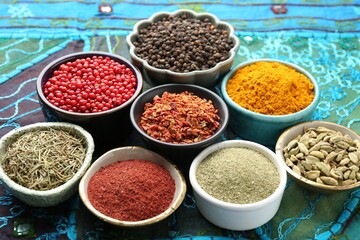 Different aromatic spices on blue tablecloth, closeup