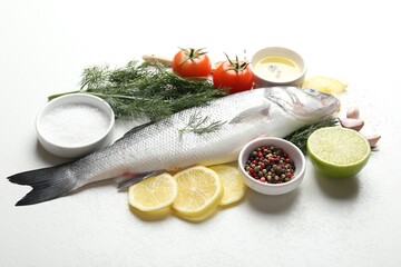 Fresh raw seabass with spices on white table. Fish and seafood delicacies