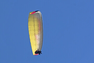 Tandem Paraglider flying in a blue sky	
