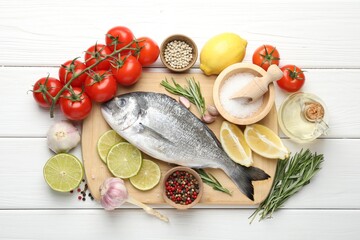 Fresh raw dourade with spices on white wooden table, flat lay. Fish and seafood delicacies