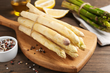 Green and white asparagus with spices on wooden table, closeup