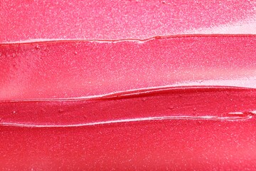 Texture of bright pink lip gloss as background, top view