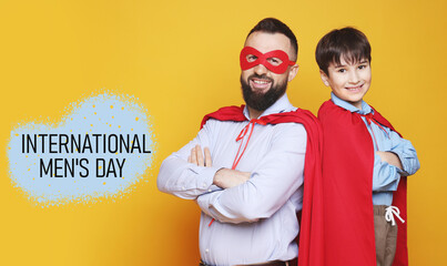 International Men's Day card. Happy man and his son dressed as superheroes against orange background