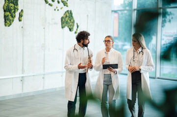 Doctors walking and discussing diagnosis in hospital corridor