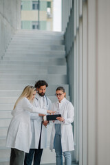 Medical team using digital tablet in hospital corridor